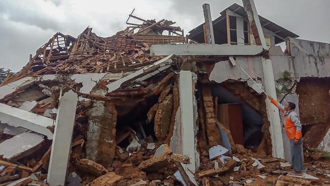 Penduduk desa memeriksa rumah mereka yang rusak setelah gempa magnitudo 5,1  di Sukabumi, Jawa Barat (10/3/2020). Hasil pemodelan menunjukkan bahwa gempabumi ini tidak berpotensi tsunami. (AFP/Handout/BNPB)