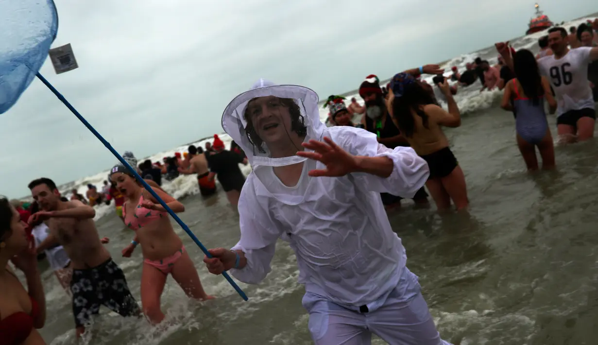 Warga Belgia menyerbu perairan Laut Utara untuk merayakan akhir pekan perrtama 2019 di Ostend, Sabtu (5/1). Cuaca dingin tidak menghalangi mereka menceburkan diri ke dalam air sebagai  tradisi tahun baru. (AP/Francisco Seco)