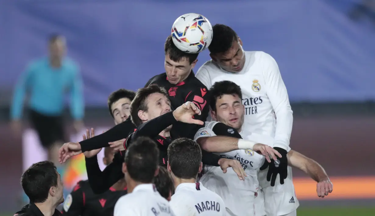 Para pemain Real Madrid dan Real Sociedad melompat berebut bola saat pertandingan lanjutan La Liga Spanyol di stadion Alfredo di Stefano di Madrid, Spanyol, Selasa (2/3/2021). Real Madrid bermain imbang atas Real Sociedad 1-1. (AP Photo/Bernat Armangue)