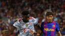 Pemain Bayern Munchen Alphonso Davies (kiri) berebut bola dengan pemain Barcelona Sergi Roberto pada pertandingan Grup E Liga Champions di Stadion Camp Nou, Barcelona, Spanyol, Selasa (14/9/2021). Bayern Munchen menang 3-0. (AP Photo/Joan Monfort)