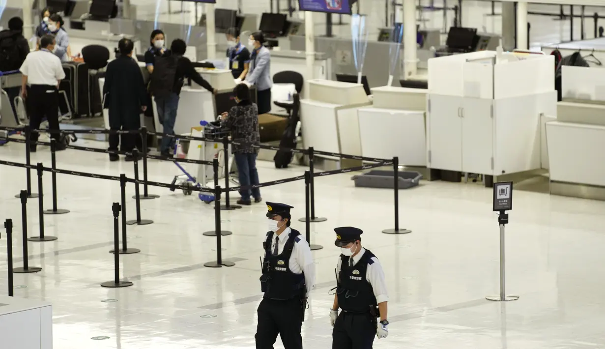 <p>Polisi berjalan-jalan di check in counter keberangkatan di Bandara Internasional Narita, timur Tokyo, Kamis (2/12/2021). Maskapai-maskapai internasional diminta menangguhkan reservasi baru pada semua penerbangan masuk ke Jepang hingga akhir Desember terkait varian Omicron. (AP Photo/Hiro Komae)</p>