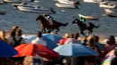 Joki memacu kudanya pada lomba pacuan kuda di sepanjang pantai di Sanlucar de Barrameda, Spanyol pada 11 Agustus 2019. Balap kuda di tepi pantai ini merupakan acara tahunan yang telag berlangsung selama lebih dari 140 tahun. (AP Photo/Javier Fergo)