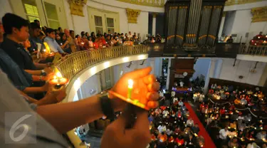 Umat Kristiani menyalakan lilin pada misa malam Natal di Gereja Immanuel, Jakarta  Sabtu (24/12). Perayaan natal berlangsung khidmat. (Liputan6.com/Angga Yuniar)