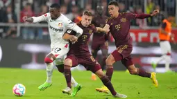 Pemain Bayer Leverkusen Callum Hudson-Odoi (kiri) berebut bola dengan pemain Bayern Munchen Joshua Kimmich pada pertandingan sepak bola Bundesliga di Allianz Arena, Munich, Jerman, 30 September 2022. Bayern Munchen menang 4-0. (AP Photo/Matthias Schrader)