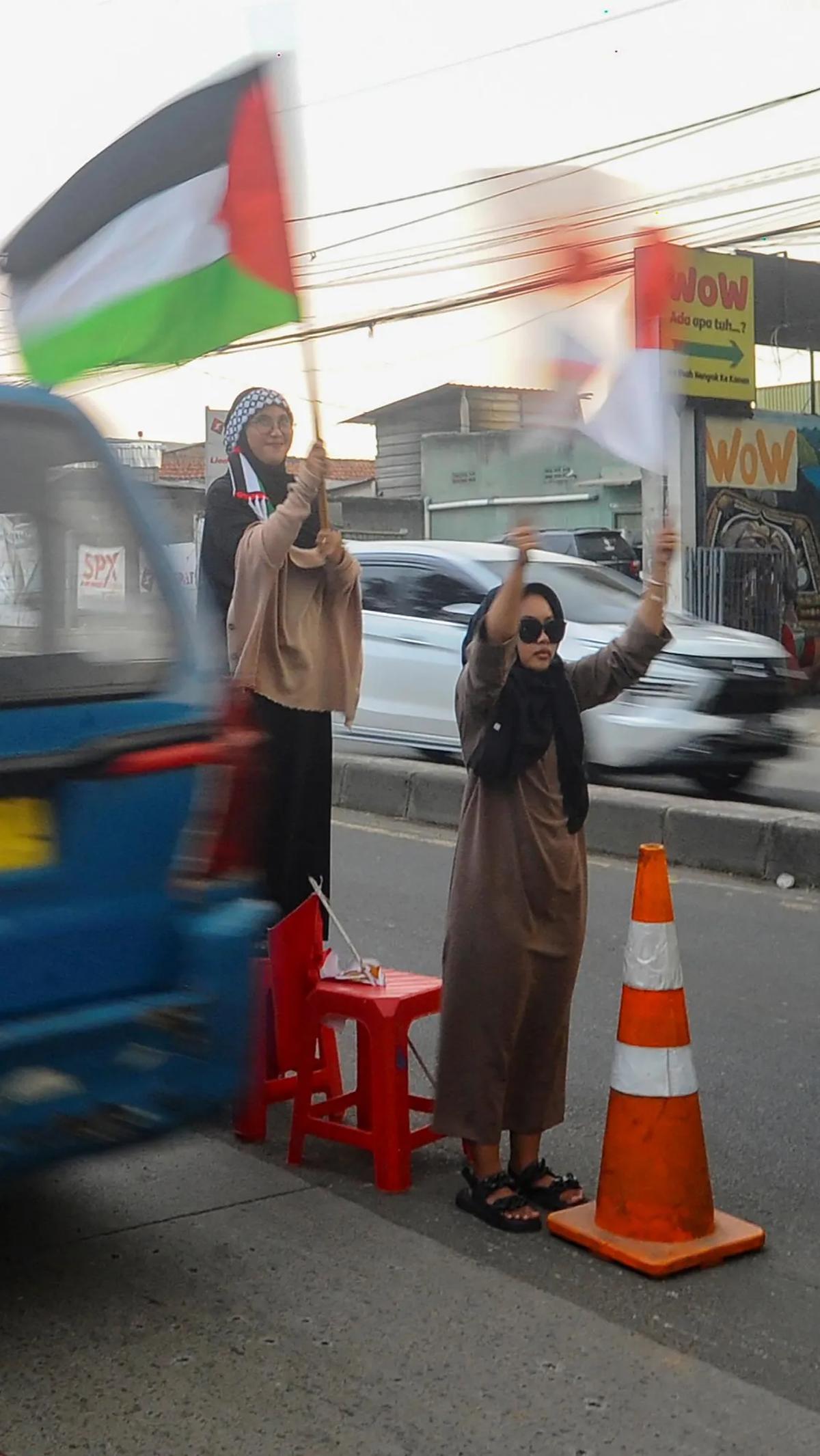 Saat menggalang dana, para santri berdiri di tengah jalan sambil mengibarkan bendera Palestina.