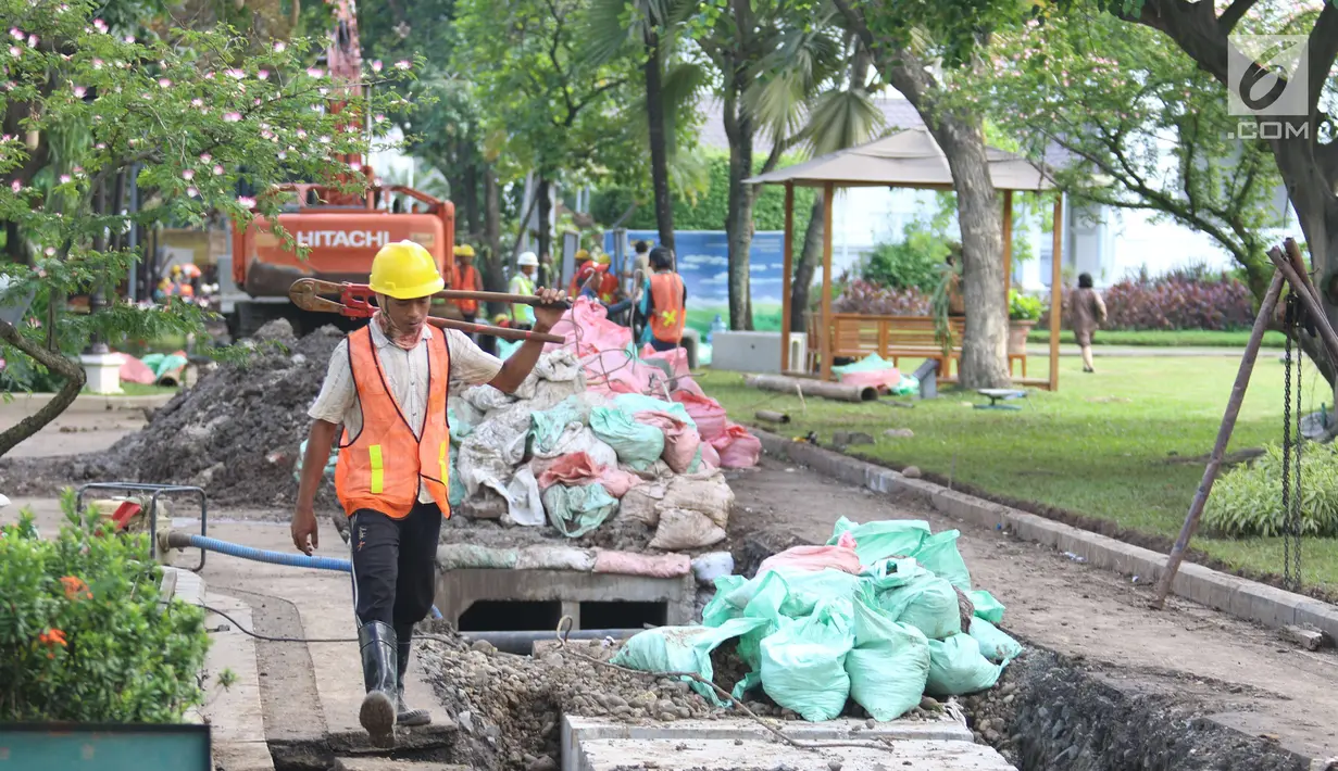 Pekerja berjalan dekat perbaikan drainase Kompleks Istana Kepresidenan, Jakarta, Senin (18/12). Presiden Jokowi memindahkan aktivitas kerja ke Istana Bogor hingga revitalisasi drainase lingkungan Istana di Jakarta selesai. (Liputan6.com/Angga Yuniar)