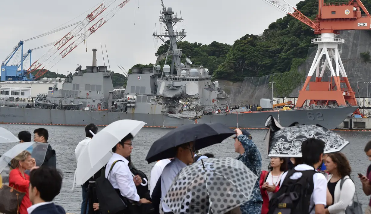 Sejumlah awak media mencari berita tentang kapal perusak USS Fitzgerald yang bertabrakan dengan kapal dagang di pelabuhan Yokosuka, Jepang (17/6). (AFP Photo/Kazuhiro Nogi)