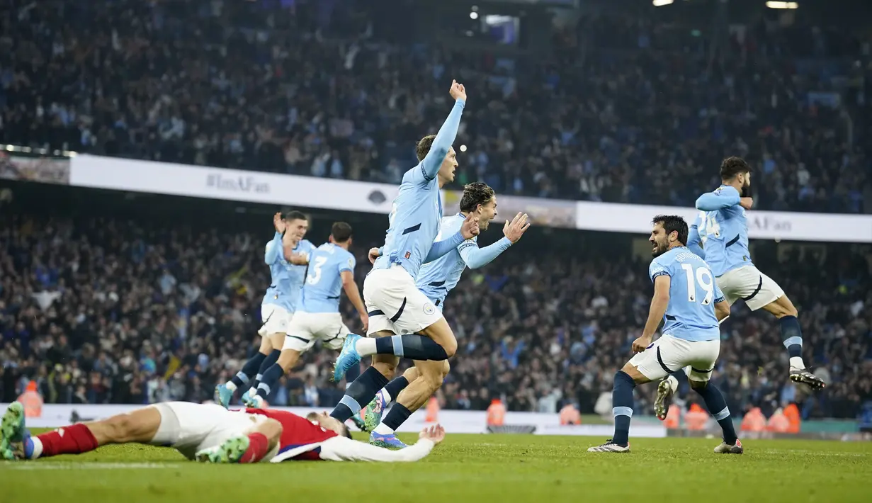Pemain Manchester City, John Stones, melakukan selebrasi setelah mencetak gol ke gawang Arsenal pada laga Liga Inggris di Stadion Etihad, Minggu (22/09/2024). (AP Photo/Dave Thompson)