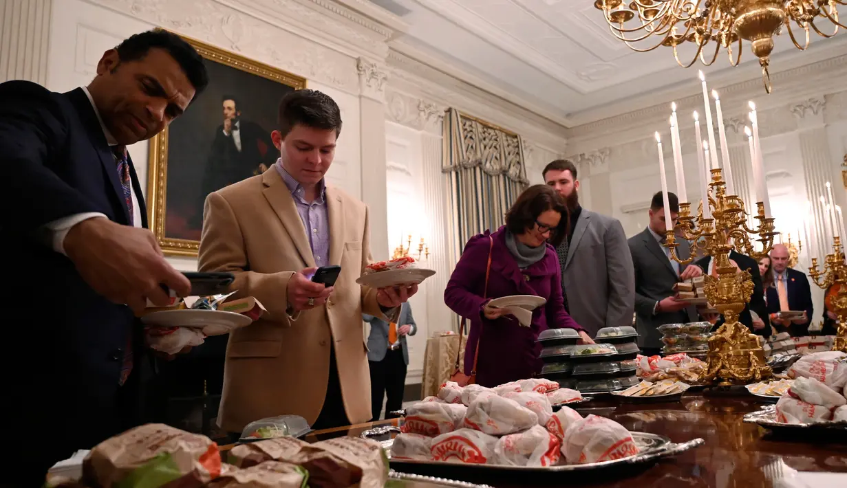 Tamu mengambil makanan cepat saji saat Presiden AS Donald Trump menjamu Clemson Tigers di Gedung Putih, Washington, Senin (14 /1). Trump merupakan pecinta makanan cepat saji. (AP Photo/Susan Walsh)