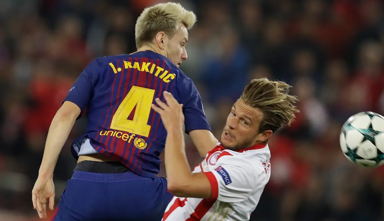 Pemain Barcelona, Ivan Rakitic berebut bola dengan pemain Olympiakos, Guillaume Gillet pada laga babak penyisihan Grup D Liga Champions di Georgios Karaiskáki, Rabu (1/11). Barcelona hanya mampu bermain imbang dengan skor 0-0. (AP/Thanassis Stavrakis)