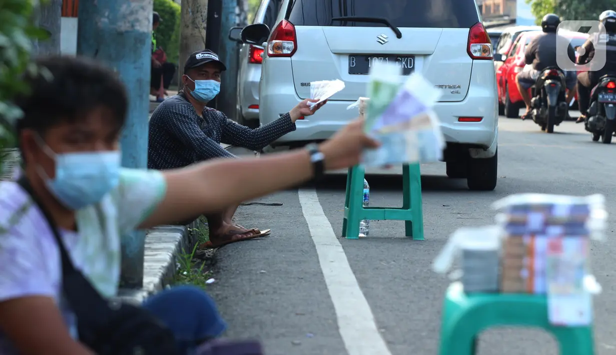 Penjual jasa penukaran uang pecahan menunggu konsumen di Jalan Otista Raya di Karawaci, Kota Tangerang, Senin (10/5/2021). Penjual jasa penukaran uang baru musiman tersebut mulai bermunculan menjelang lebaran yang dikenakan tarif jasa sebesar 10 persen. (Liputan6.com/Angga Yuniar)