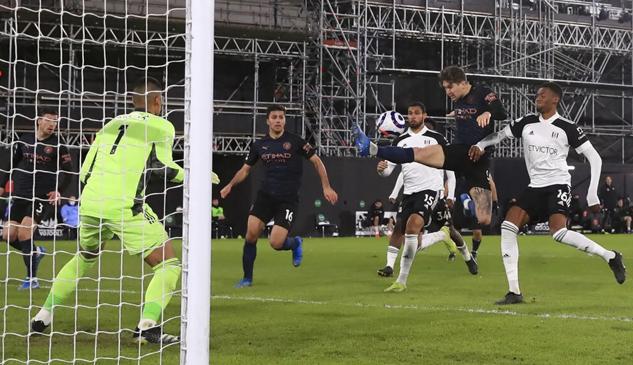 Pemain Manchester City John Stones (kedua kanan) mencetak gol ke gawang Fulham pada pertandingan Liga Inggris di Stadion Craven Cottage, London, Inggris, Sabtu (13/3/2021). Manchester City menang 3-0. (Adam Davy/Pool via AP)