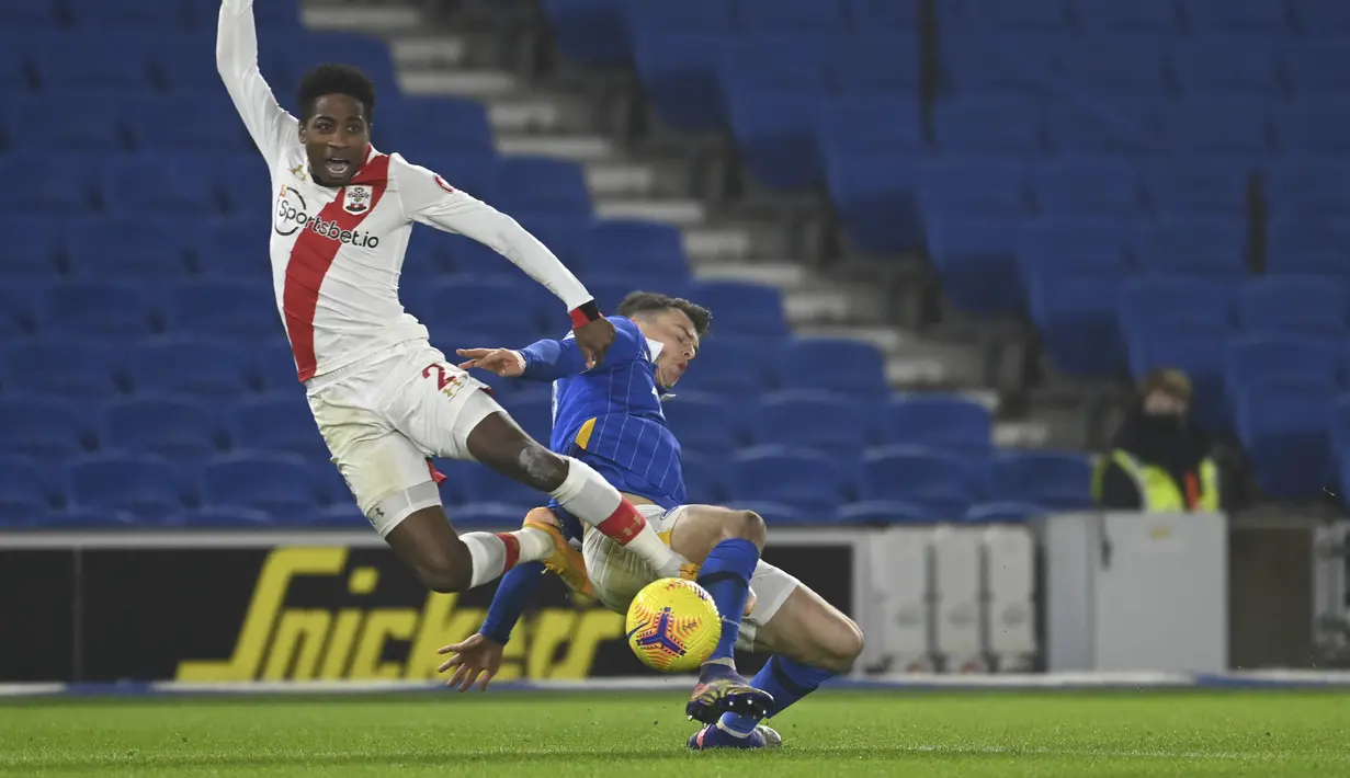 Bek Southampton, Kyle Walker-Peters berebut bola dengan gelandang Brighton & Hove Albion, Solly March pada pertandingan lanjutan Liga Inggris di Stadion Falmer, Brighton, Inggris, Selasa (8/12/2020). Southampton Menang Tipis atas Brighton 2-1. Mike Hewitt / Pool Via AP)
