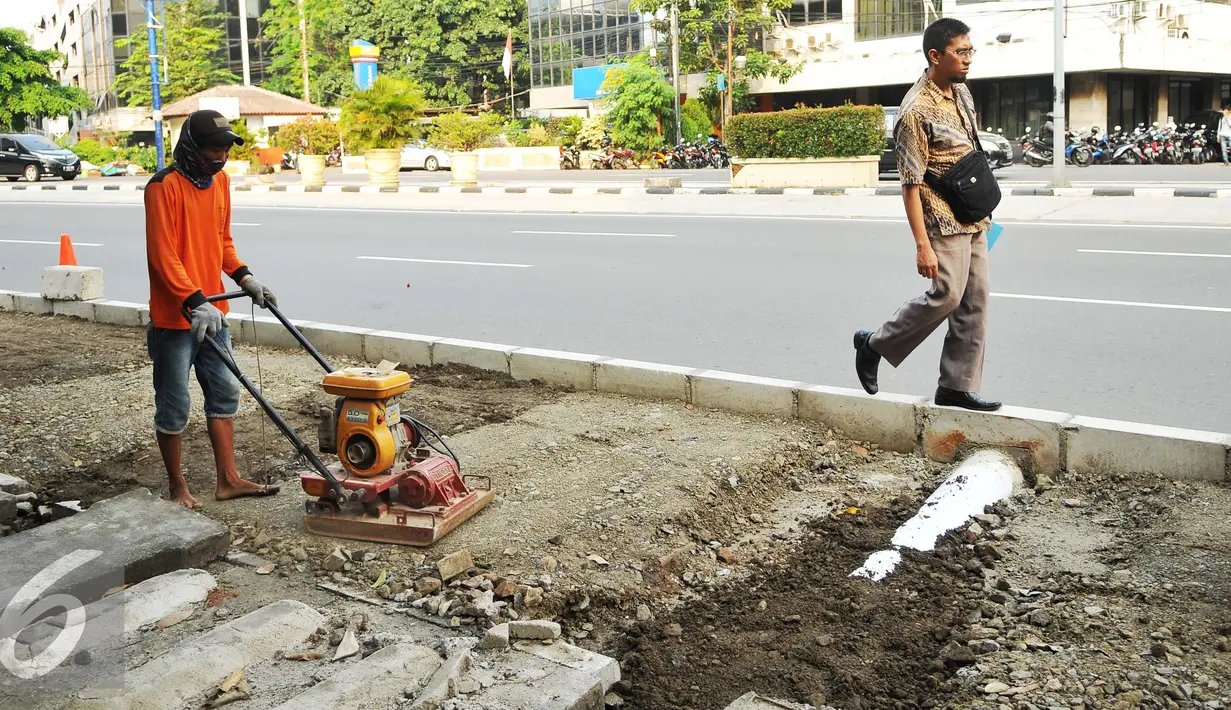 Pekerja menyelesaikan pembangunan trotoar di jalan Suryopranoto, Jakarta, Selasa (2/8). Pemprov DKI telah melakukan perbaikan dan pembangunan trotoar untuk kenyamanan pejalan kaki di 48 lokasi. (Liputan6.com/Gempur M Surya) 