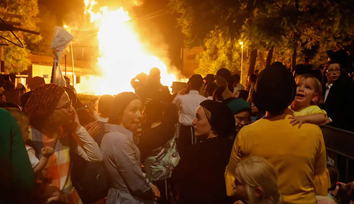 Sekelompok Yahudi ultra ortodoks antizionis berkumpul dekat api unggun di Yerusalem ultra-Ortodoks Mea Shearim, Rabu (2/5). Selain menyalakan api unggun, mereka juga akan mengunjungi tempat peristirahatan terakhir dari Bar Yochai. (MENAHEM KAHANA / AFP)