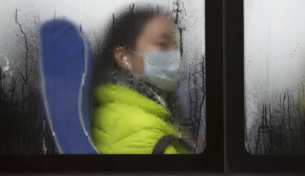 Seorang penumpang memakai masker di dalam bus, Beijing, Cina, (13/11). Pemerintah Cina mengumumkan bahwa kualitas udara mengalami penurunan akibat tercemar polusi. (REUTERS/Jason Lee)