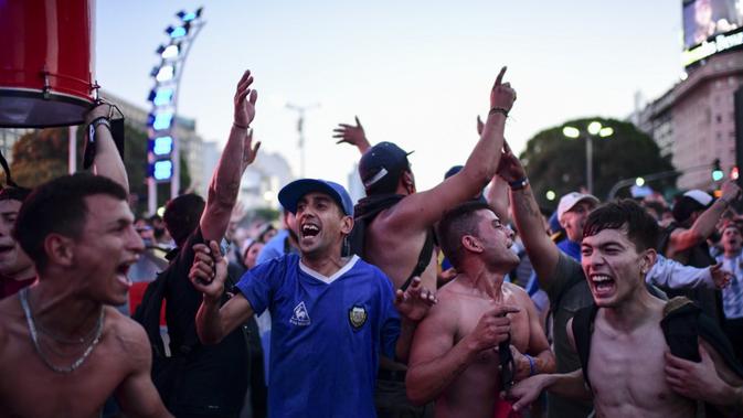 Fans legenda sepak bola Argentina Diego Maradona berkumpul untuk memberi penghormatan pada hari kematiannya di Obelisk, Buenos Aires, Argentina, 25 November 2020. Argentina mengumumkan tiga hari berkabung nasional atas meninggalnya Diego Maradona. (RONALDO SCHEMIDT/AFP)