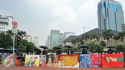 Sejumlah mahasiswa Trisakti menggelar aksi dengan memajang gambar mural bertema kemanusiaan di Bundaran Patung Kuda, Jakarta, Kamis (12/5). Aksi ini bertujuan untuk memperingati tragedi trisakti 12 Mei 98. (Liputan6.com/Yoppy Renato)