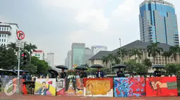 Sejumlah mahasiswa Trisakti menggelar aksi dengan memajang gambar mural bertema kemanusiaan di Bundaran Patung Kuda, Jakarta, Kamis (12/5). Aksi ini bertujuan untuk memperingati tragedi trisakti 12 Mei 98. (Liputan6.com/Yoppy Renato)