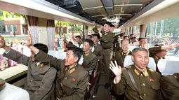 Para pengembang roket balistik strategis Hwasong-12 berada di dalam bus menyapa ribuan warga setibanya di Pyongyang, Korea Utara (19/5).  (AFP Photo/KCNA Via KNS/Str/South Korea Out) 
