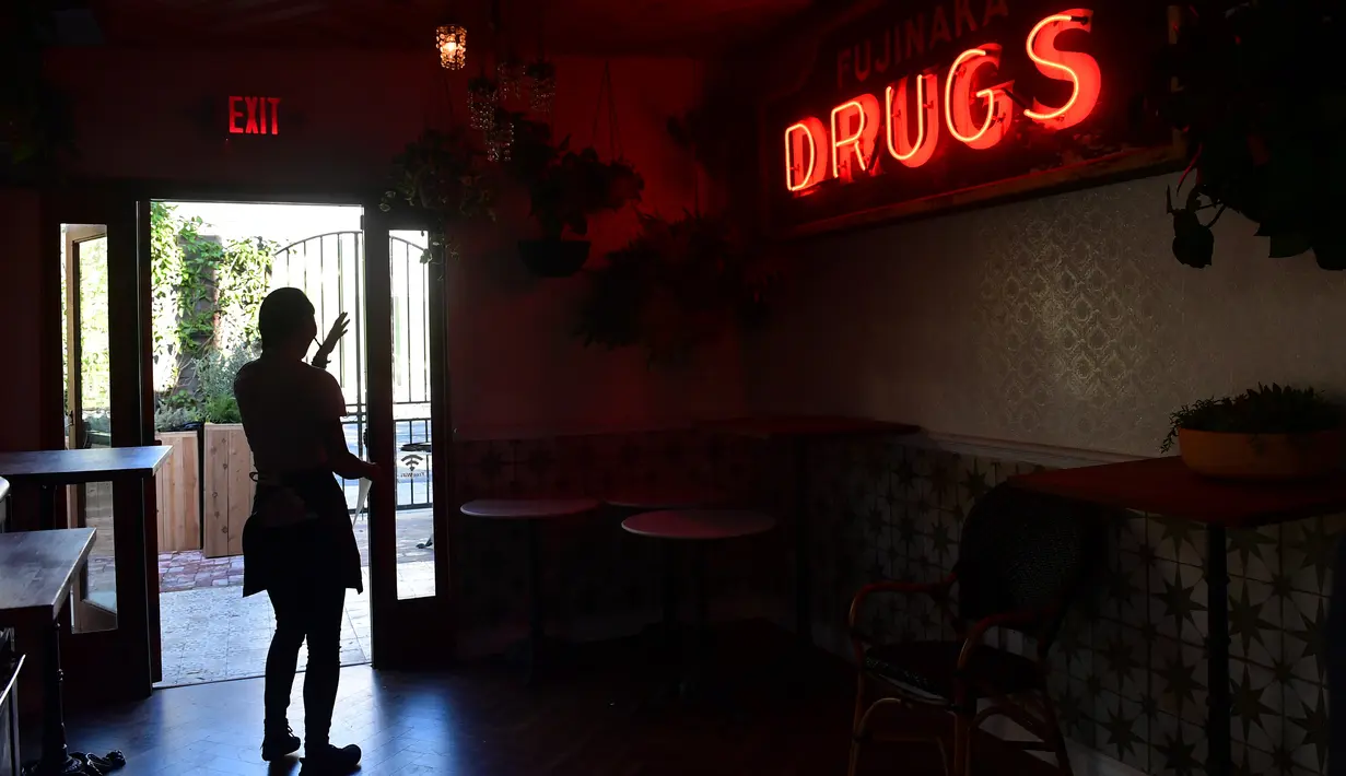 Seorang pramusaji berjalan melalui pintu di Lowell Cafe di Hollywood Barat, California (30/9/2019). Kafe ini merupakan restoran farm-to-table pertama yang menyoroti masakan dan ganja. (AFP Photo/Frederic J. Brown)