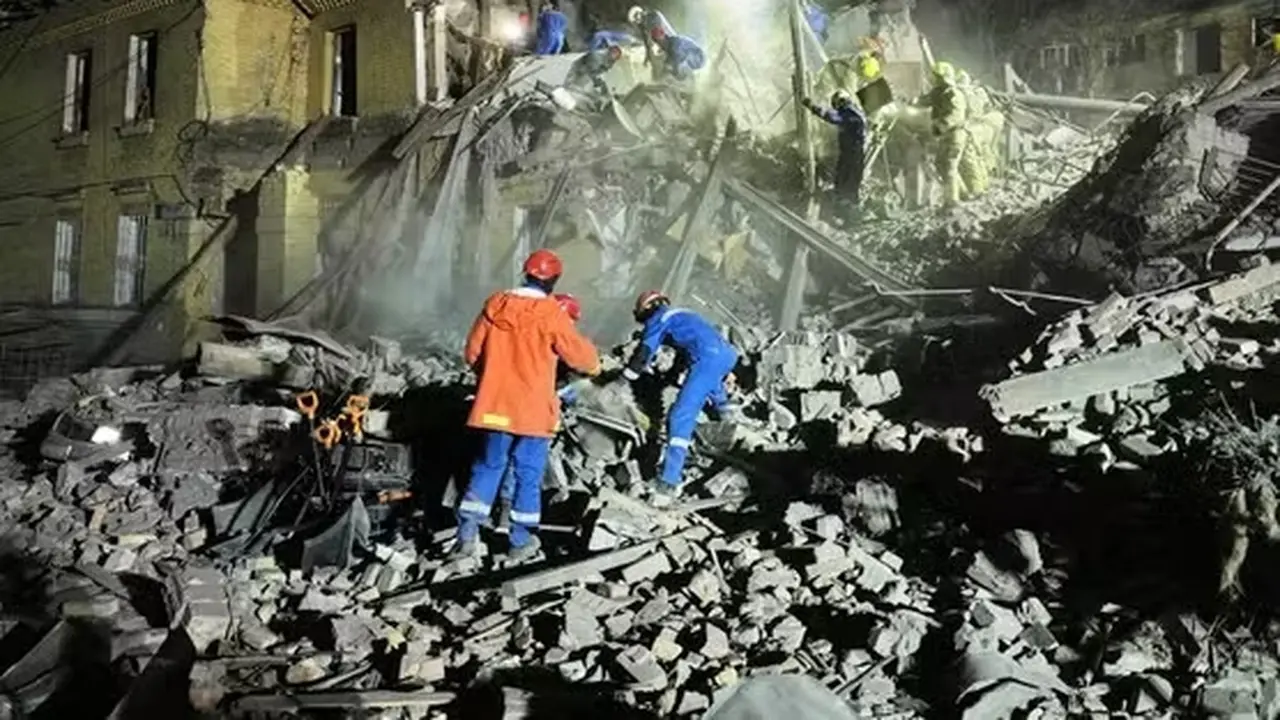Petugas penyelamat Ukraina membersihkan puing-puing setelah serangan rudal balistik Rusia di Kyiv, Ukraina, Kamis dini hari, 24 April 2025. (EFREM LUKATSKY / AP)