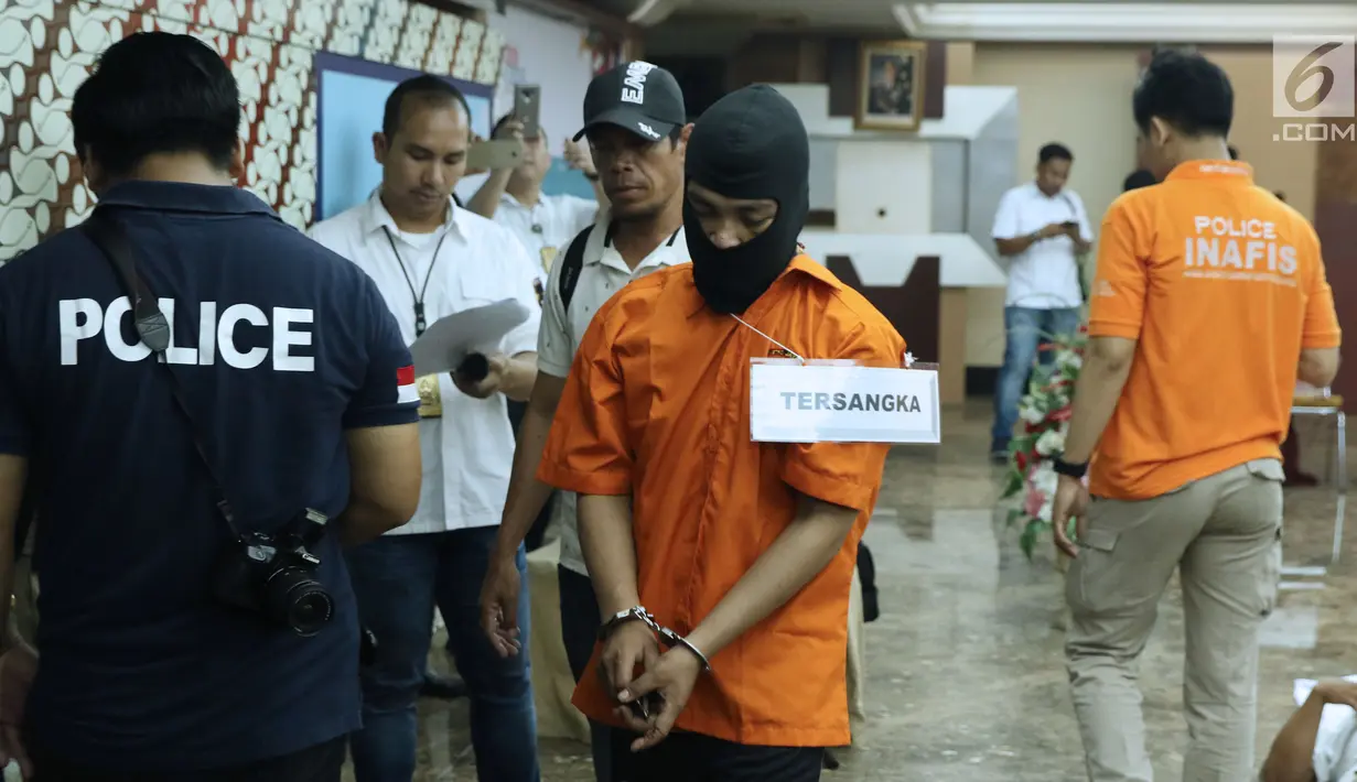 Tersangka HS pelaku kasus pembunuhan satu keluarga di Bekasi digiring untuk melakukan pra-rekonstruksi di Polda Metro Jaya, Jakarta, Senin (19/11). 35 adegan diperagakan dari 57 yang akan diperagakan saat rekonstruksi. (Liputan6.com/Helmi Fithriansyah)