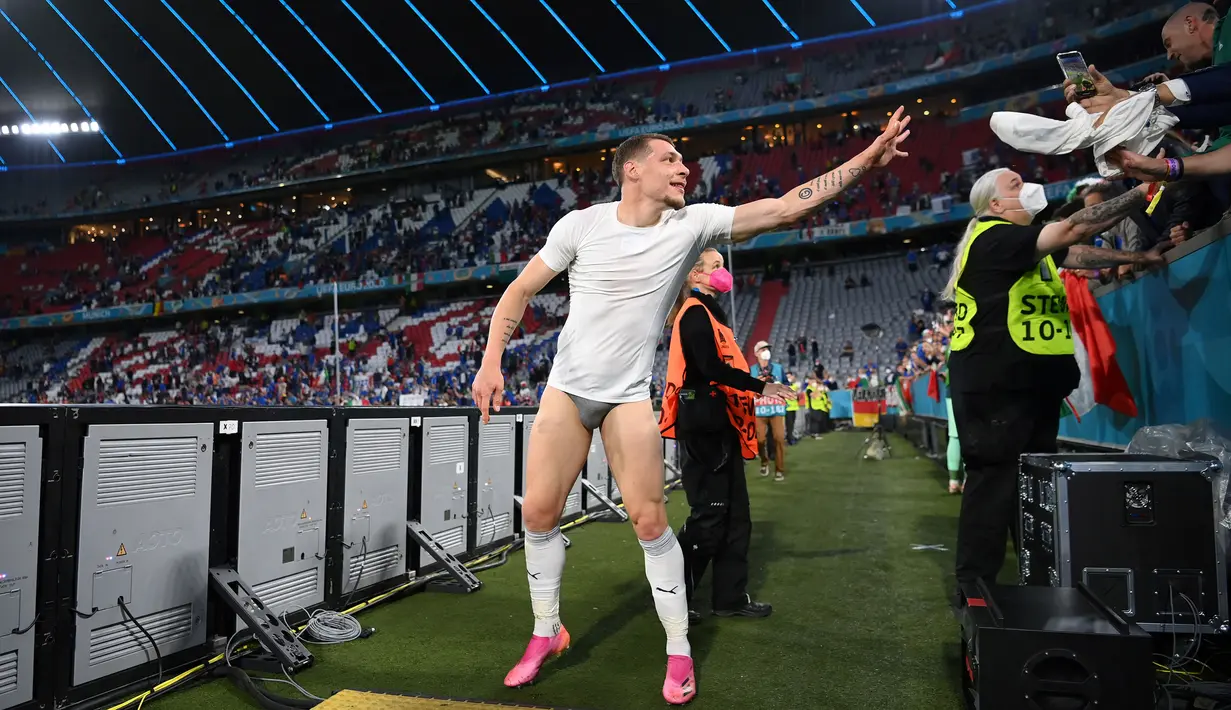 Penyerang Italia, Andrea Belotti melemparkan celana pendeknya kepada para suporter saat dirinya merayakan kemenangan setelah pertandingan Perempatfinal EURO 2020 antara Belgia dan Italia yang berlangsung di Allianz Arena, Munich pada 2 Juli 2021.
(AFP/Pool/Matthias Hangst)