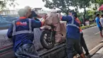 Pekerja tengah mengepak sepeda motor yang akan dikirim melalui jasa pengiriman dengan kereta api di Kawasan Stasiun Senen, Jakarta, Kamis (13/4/2023).(Liputan6.com/Angga Yuniar)