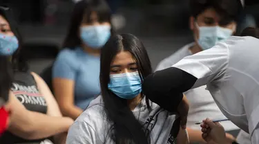 Seorang perawat menginokulasi seorang remaja wanita dengan dosis booster vaksin Pfizer melawan COVID-19 di Mexico City (9/2/2022). Menteri kesehatan Meksiko melaporkan 9.242 kasus baru COVID-19 dan 206 kematian pada Senin (7/2/2022). (AFP/Claudio Cruz)