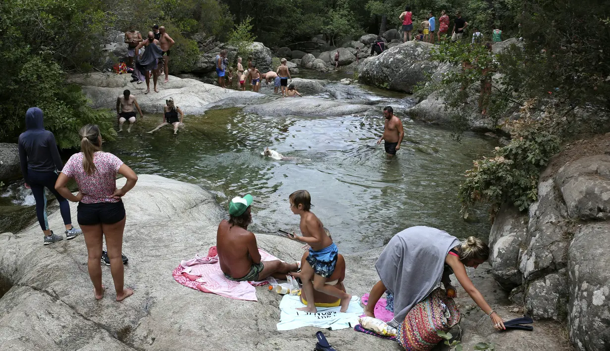 Wisatawan menikmati kolam alami Polischellu di hutan Bavella di celah Bavella dekat Zonza di selatan pulau Corsica, Mediterania Prancis (25/8/2021).  Situs Bavella penuh sesak dengan turis selama musim panas. (AFP/Pascal Pochard-Casabianca)