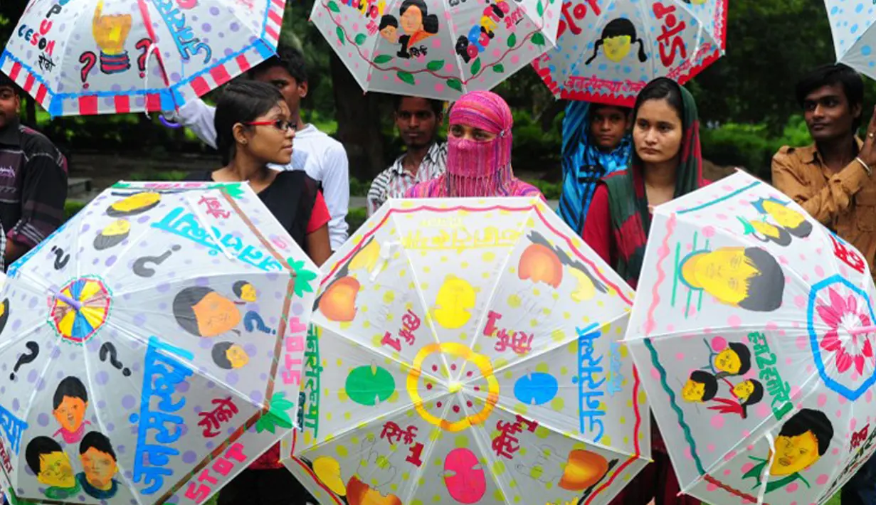 Siswa melukis payung dengan tema ‘Populasi Dunia’ di Allahabad pada 11 Juli 2013. Sebuah penelitian baru dari PBB memprediksi bahwa India akan melampaui China sebagai negara dengan penduduk terbanyak pada tahun 2022. (AFP PHOTO/SANJAY KANOJIA)