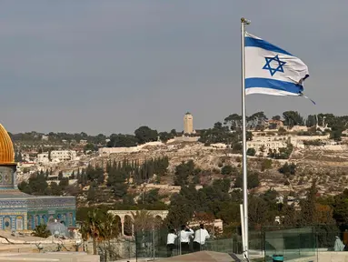 Bendera Israel berkibar di atap sbangunan di Kota Tua Yerusalem di seberang Dome of the Rock di kompleks masjid Al-Aqsa, (5/12). Menurut pejabat AS, Presiden AS Donald Trump akan mengakui Yerusalem sebagai ibu kota Israel. (AFP Photo/Thomas Coex)