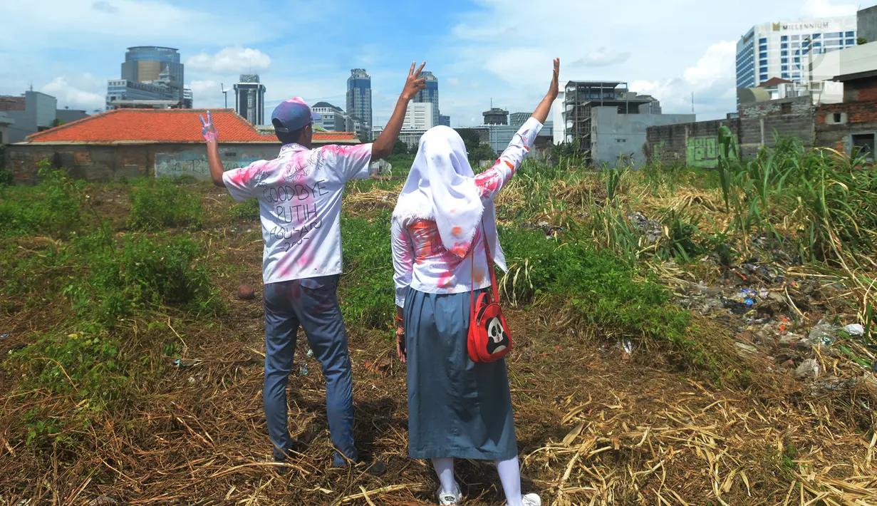 Dua pelajar Sekolah Menengah Atas (SMA) berpose dengan seragam mereka yang telah dicorat-coret di kawasan Cideng, Jakarta, Kamis (12/4). Aksi coret mencoret seragam tersebut dilakukan setelah selesai menempuh Ujian Nasional (UN). (Merdeka.com/Imam Buhori)