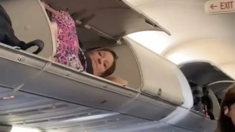 Potret penumpang tidur di atas tempat penyimpanan pesawat