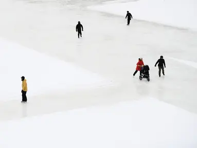 Orang-orang menyusuri Rideau Canal Skateway pada hari pembukaannya di tengah pandemi COVID-19 di Ottawa, Ontario, Kamis (28/1/2021). Kanal Rideau adalah Situs Warisan Dunia UNESCO. (Justin Tang/The Canadian Press via AP)