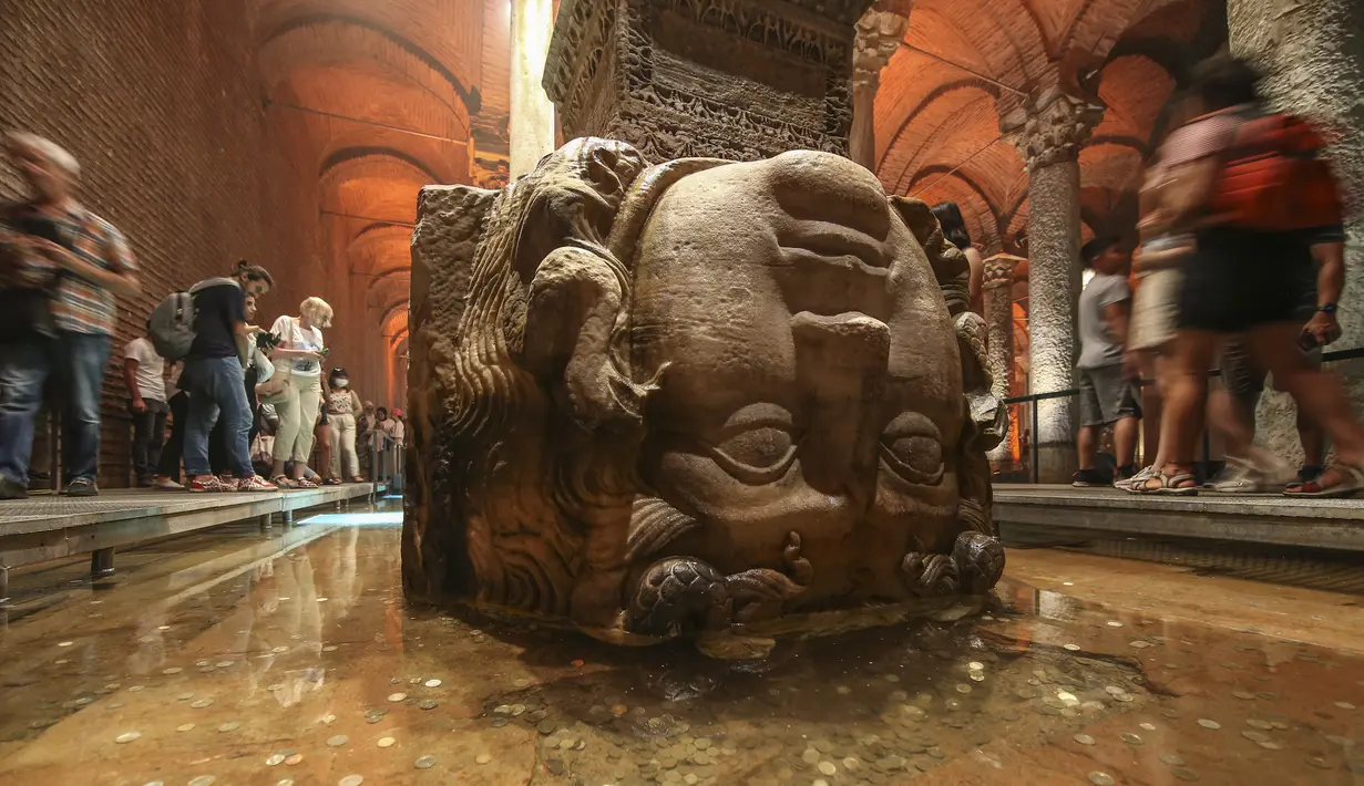 Pengunjung berjalan melewati kolom Medusa di Basilika Cistern era Bizantium di Istanbul, Turki, Rabu, 27 Juli 2022. Letaknya di bawah tanah kota Istanbul. Dari luar terlihat sederhana, karena sebagian besar struktur ini memang terletak di bawah tanah. (AP Photo/Emrah Gurel)