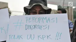 Massa yang tergabung dalam Koalisi Masyarakat Menyelamatkan KPK membentangkan poster saat aksi menolak UU KPK di Gedung DPR, Jakarta, Selasa (17/9/2019). Dalam aksinya massa membawa poster bertuliskan kekecewaan terhadap Jokowi dan DPR karena mengesahkan UU KPK. (merdeka.com/Iqbal S. Nugroho)