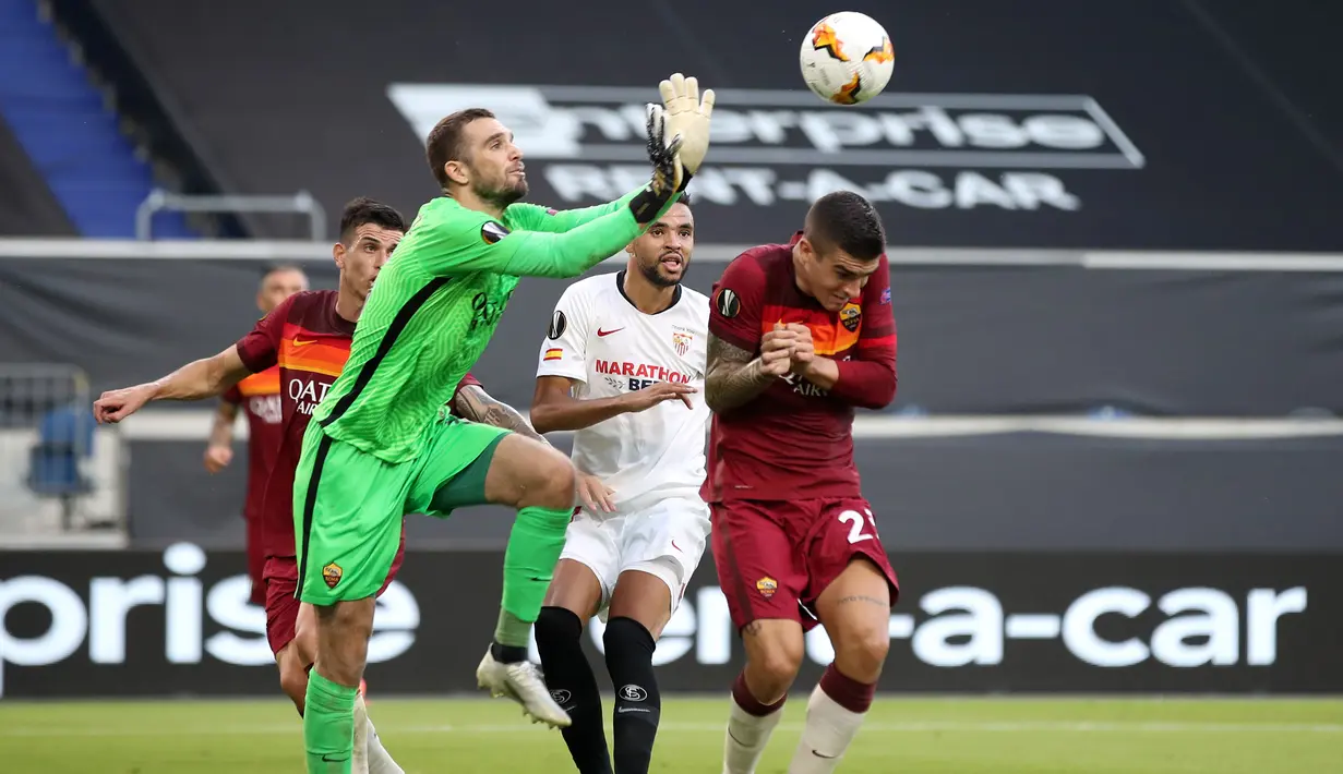 Kiper AS Roma, Pau Lopez, berusaha menepis bola saat menghadapi Sevilla dalam laga babak 16 besar Liga Europa 2019/2020 di MSV-Arena, Jerman, Jumat (7/8/2020) dini hari WIB. Sevilla menang 2-0 atas AS Roma. (AFP/Friedemann Vogel/pool)