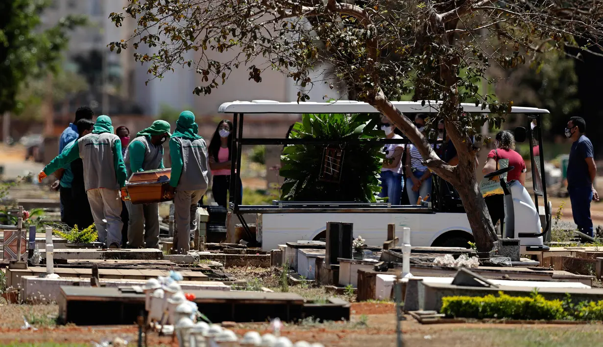 Petugas membawa peti jenazah berisi Luzia Paulina Santos (82), yang dikatakan meninggal karena COVID-19, di pemakaman Campo da Esperanca di Brasilia, Brasil, Kamis (3//9/2020). Brasil melaporkan rata-rata lebih dari 1.000 kematian setiap hari akibat corona sejak akhir Mei. (AP Photo/Eraldo Peres)