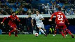 Pemain Real Madrid, Lucas Vazquez mengejar bola saat menjamu Numancia pada leg kedua babak 16 besar Copa del Rey di Santiago Bernabeu, Kamis (11/1). Meski bermain imbang, Real Madrid lolos ke perempat final dengan agregat skor 5-2. (AP/Francisco Seco)