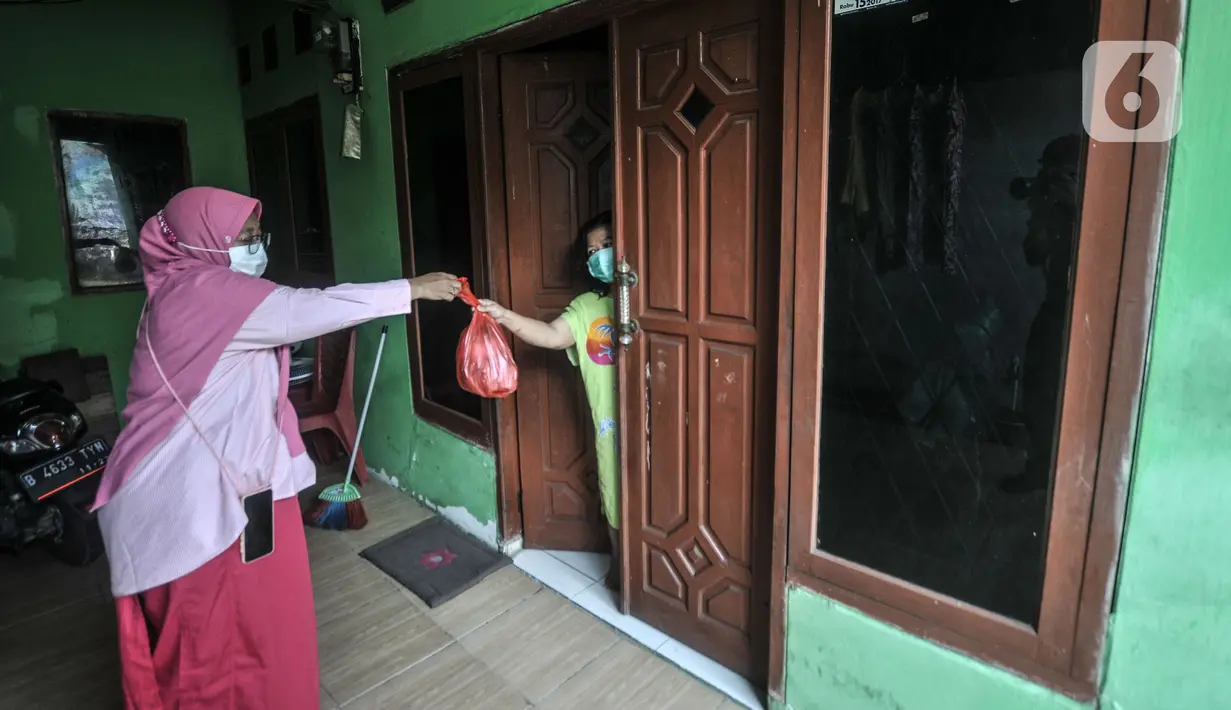 Satgas Covid-19 memberikan makanan kepada warga yang isolasi mandiri di RT 003 RW 003, Kelurahan Cilangkap, Kecamatan Cipayung, Jakarta, Selasa (25/5/2021). Jumlah warga yang tepapar Covid-19 bertambah menjadi 104 orang akibat klaster silaturahmi saat Lebaran lalu. (merdeka.com/Iqbal S Nugroho)