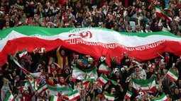 Wanita Iran bersorak sambil mengibarkan bendera negaranya saat menyaksikan laga kualifikasi Piala Dunia 2022 antara Iran dengan Kamboja di Stadion Azadi, Teheran, Iran, Kamis (10/10/2019). Wanita Iran diizinkan menonton bola ke stadion setelah seorang wanita membakar dirinya. (AP Photo/Vahid Salemi)