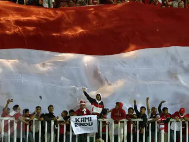Suporter bersorak di bawah bendera Merah Putih raksasa jelang menyaksikan laga final pertama Piala AFF 2016 antara Indonesia melawan Thailand di Stadion Pakansari, Bogor, Rabu (14/12). Indonesia unggul 2-1 atas Thailand. (Liputan6.com/Helmi Fithriansyah)