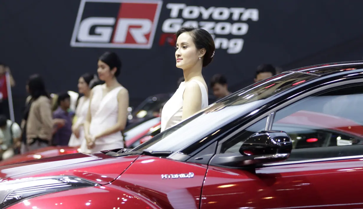 Sales Promotion Girl (SPG) berada di depan kendaraan yang dipamerkan di GIIAS 2019, ICE BSD, Kamis (25/7). Kehadiran SPG tersebut selain untuk menarik perhatian pengunjung juga bisa memberikan informasi tentang produk. (Bola.com/M Iqbal Ichsan)