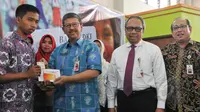 Kepala Dinas Pendidikan Arie Budhiman (kedua kiri) bersama Direktur Utama Bank DKI Eko Budiwiyono (kedua kanan) secara simbolis memberikan Kartu Jakarta Pintar (KJP) di SMK 56 Pluit, Jakarta, Kamis (21/5/2015). (Liputan6.com/Herman Zakharia)