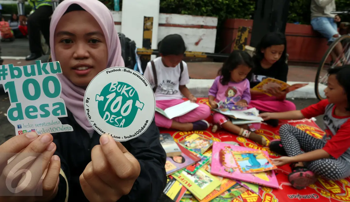 Seorang wanita memperlihatkan stiker saat kampanye "Budayakan Membaca dari Desa untuk Indonesia" saat berlangsungnya Hari Bebas Kendaraan Bermotor atau Car Free Day (CFD), Jakarta, Minggu (2/4). (Liputan6.com/Johan Tallo)