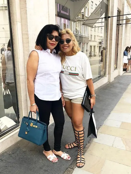 Kali ini keduanya tampil serasi dalam balutan baju warna putih. Felicia tampil simple dalam paduan t-shirt Gucci, short pants. Sementara sang ibunda memadukan sleeveless blouse dengan celana panjang warna hitam.  (Instagram/feliciahutapeaaa)