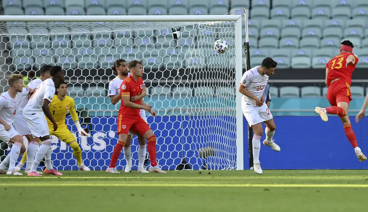 Wales baru berhasil menyamakan kedudukan pada menit ke-74 lewat tandukan gelandang Kieffer Moore (kanan) memanfaatkan umpan dari Joe Morrell. Skor berubah 1-1. (Foto: AP/Darko Vojinovic/Pool)