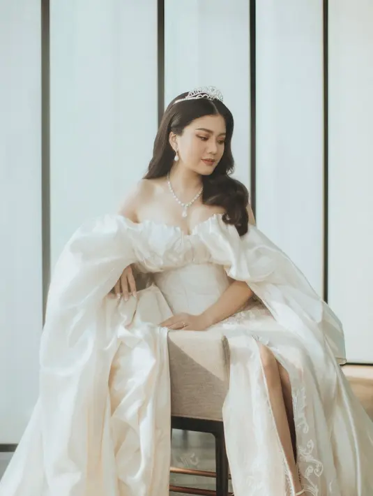 <p>Wedding robe-nya nggak kalah memukau. Valencia memilih robe berpotongan off shoulder, kombinasi satin dan lace rancangan Monica Ivena. [Foto: IG/morden.co/sincerelove.photo].</p>